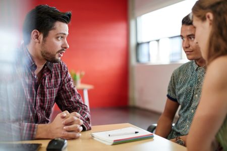 Unposed group of creative business people in an open concept office brainstorming their next project.