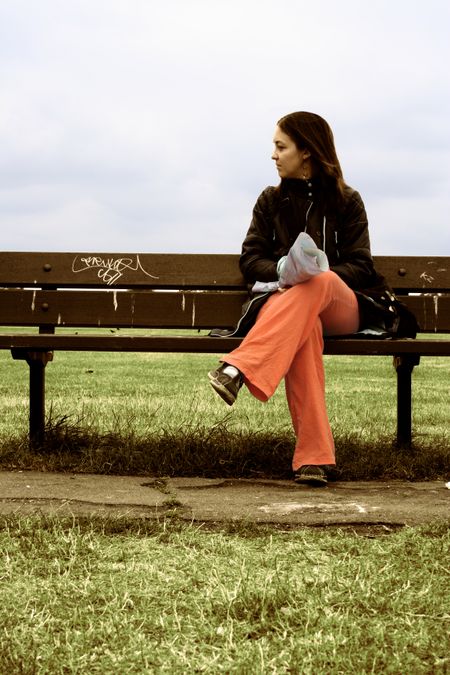 beautiful girl seating on a park bench - classic look