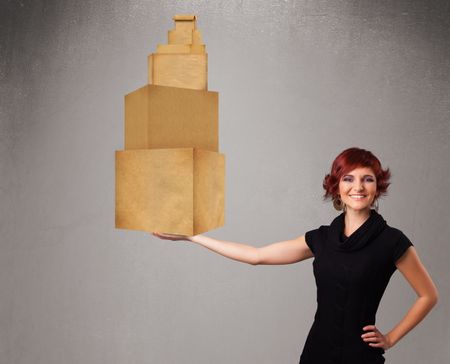 Attractive young lady holding a set of brown cardboard boxes