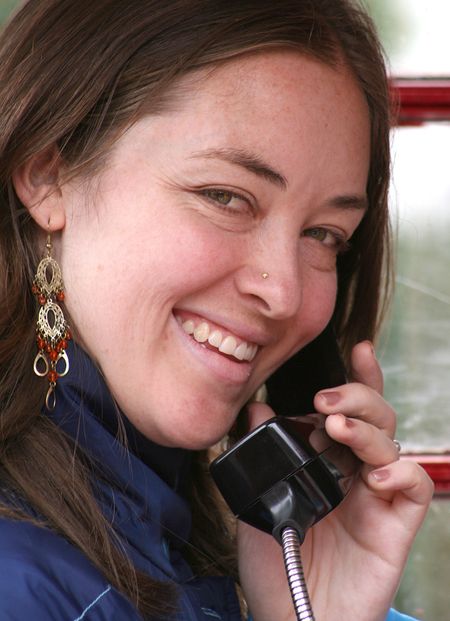 beautiful girl smiling whilst talking on the phone inside a cabin