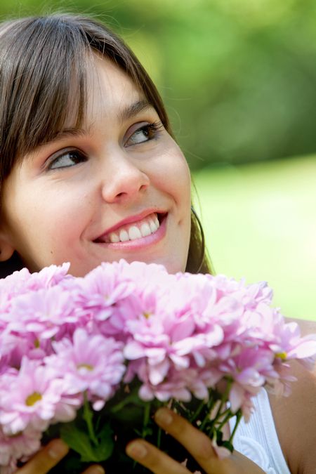 Beautiful woman portrait with flowers in a park