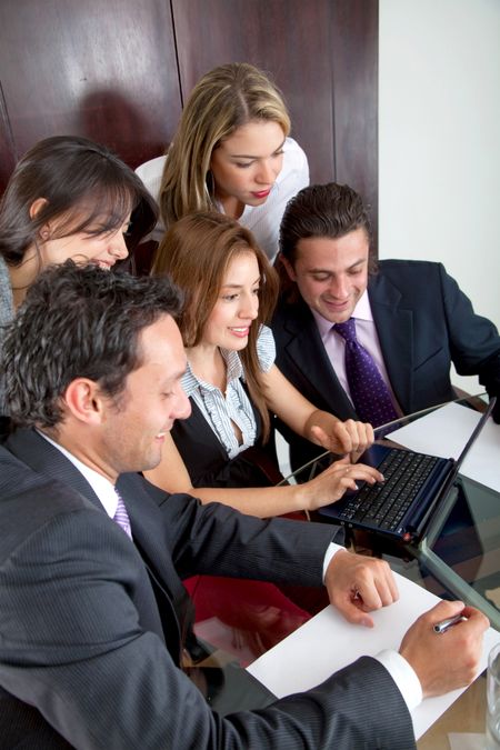 Happy business team working with a laptop at the office