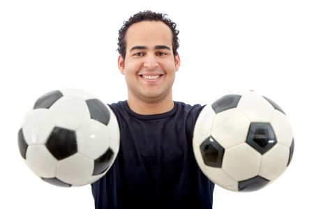 casual man smiling and holding soccer balls in his hands - isolated over white