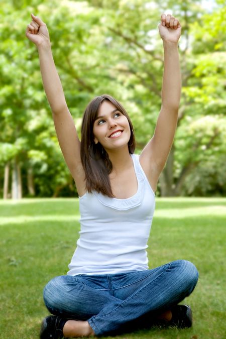 casual woman full of success outdoors with arms up