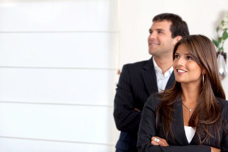 business couple smiling and looking happy in an office