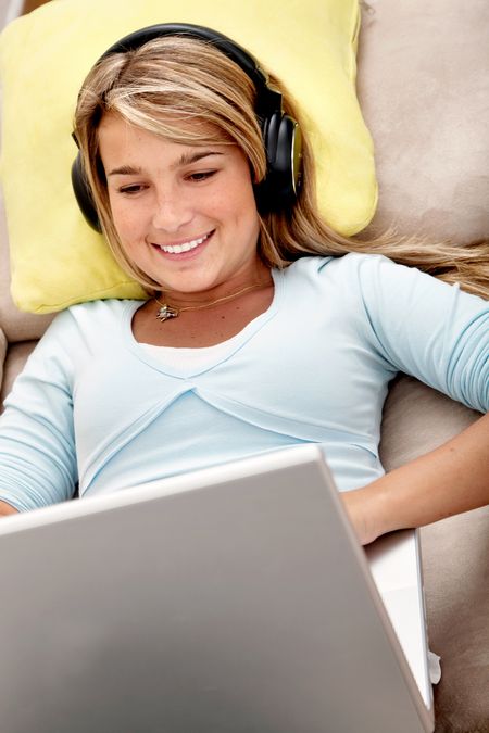 Casual student listening to music on the computer while studying at home