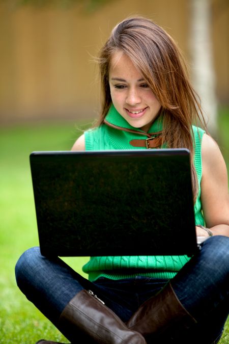 Woman working on a laptop computer outdoors
