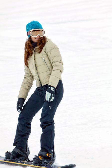 beautiful girl smiling and snowboarding in the piste