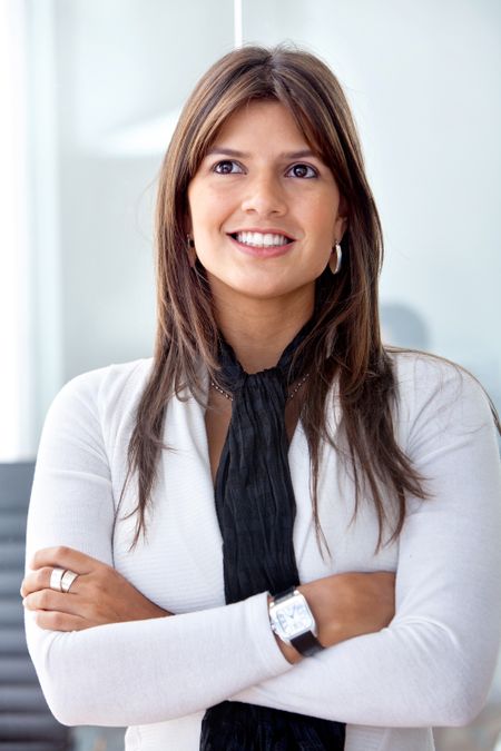 Confident business woman smiling and looking up in her office