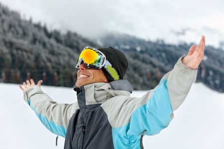 skier smiling full of joy with his arms up