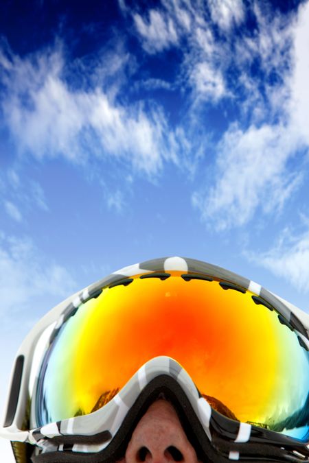 skier wearing ski glasses over a blue sky
