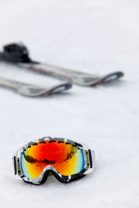 skis and ski glasses over the snow in the mountains