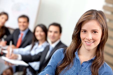 Business woman smiling leading a team during an office meeting