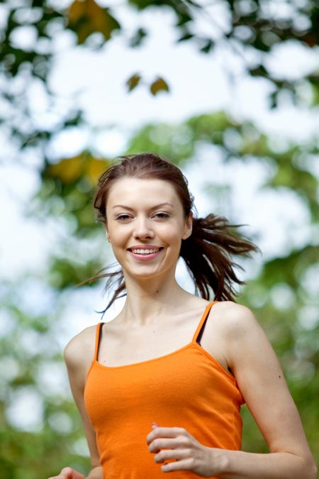 Beautiful happy woman portrait running in the park