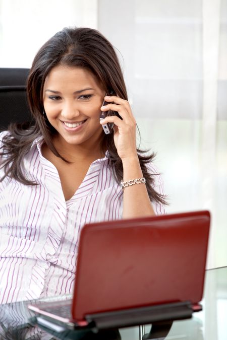 business woman smiling on the phone in her office