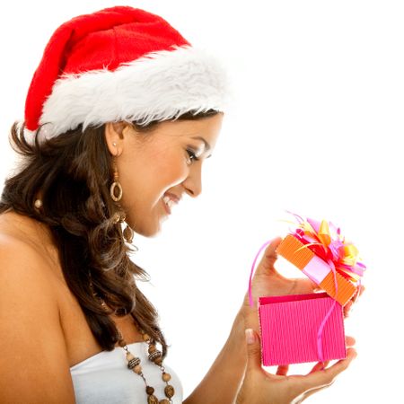 Christmas woman wearing a santa hat smiling opening a gift