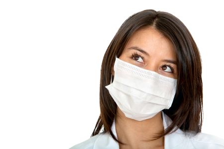 Pensive female doctor with facemask isolated over a white background