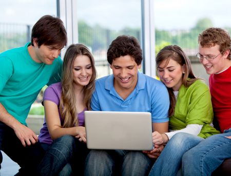 Happy group of friends with a laptop