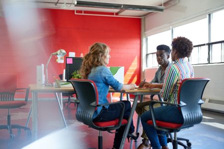 Unposed group of creative business people in an open concept office brainstorming their next project.