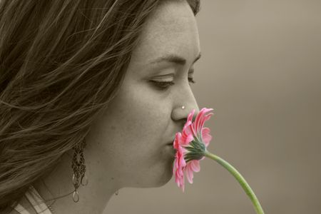 beautiful girl kissing a pink daisy