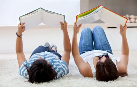 Couple of girls studying on the floor at home