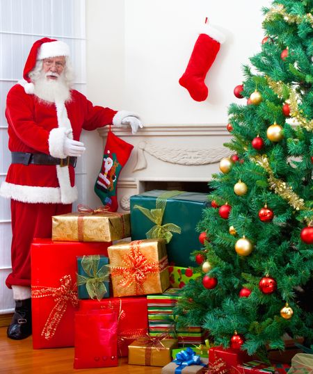 Santa with gifts next to a Christmas tree