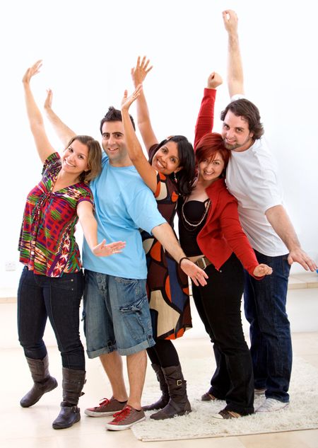 Casual group of excited friends with arms up at home