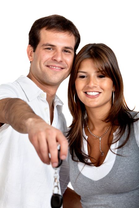 Beautiful couple giving some keys isolated on white