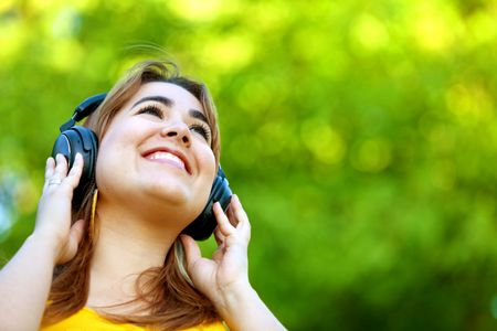 Beautiful woman with earphones listening to music outdoors