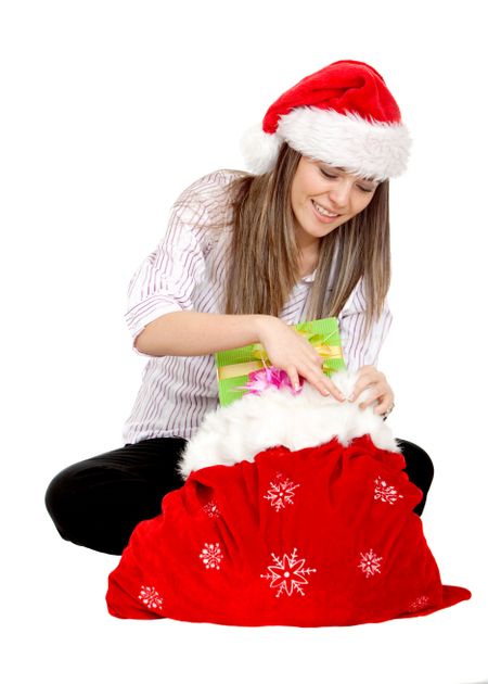 Girl with Santa hat opening gifts isolated on white