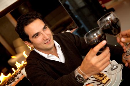 Man at a romantic dinner toasting with wine