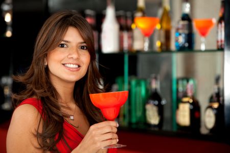 Beautiful woman at the bar drinking a cocktail