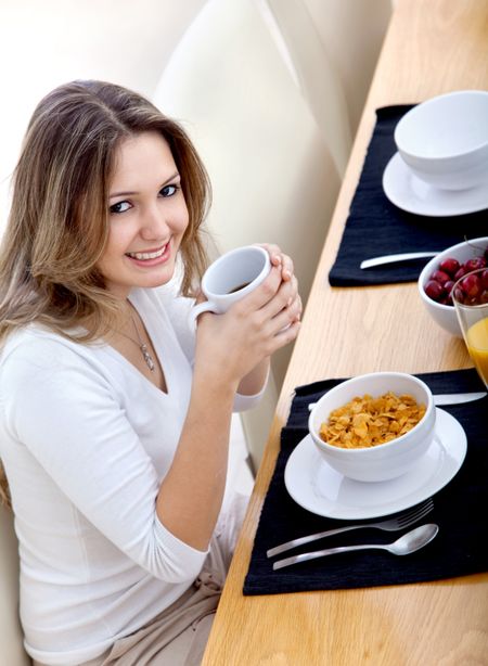 Beautiful woman eating her breakfast at home