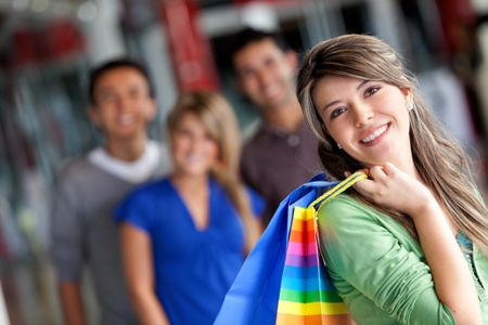 Beautiful woman smiling at a shopping center with bags