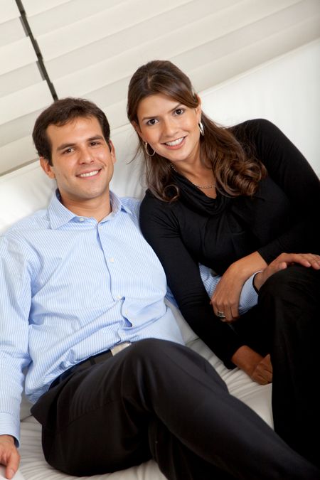 Loving business couple sitting on a sofa and smiling
