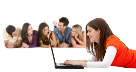 Girl lying on the floor with a computer and her friends behind her isolated on white