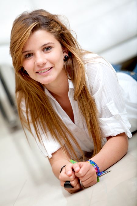 Beautiful young girl lying on the floor smiling