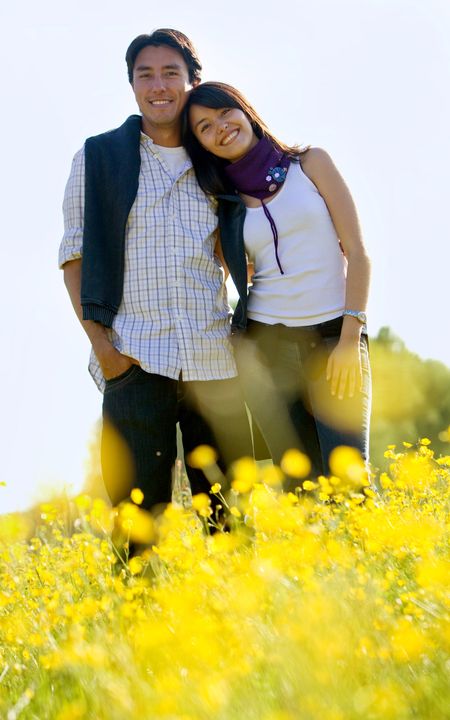 Beautiful young couple in a meadow smiling