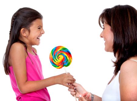 Happy mom giving a candy to her daughter isolated on white