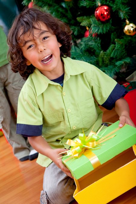 Happy kid opening a Christmas gift and smiling