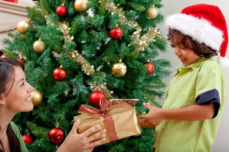 Woman giving a Christmas present to a boy