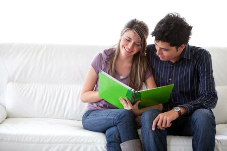 Couple of students sitting on the couch with a notebook
