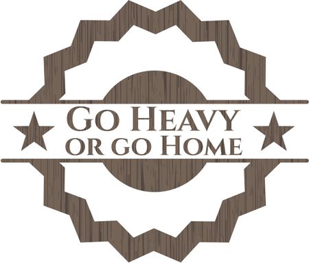 Go Heavy or go Home badge with wooden background