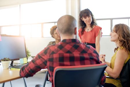 Unposed group of creative business people in an open concept office brainstorming their next project.