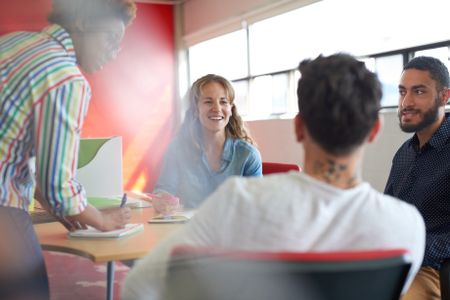 Unposed group of creative business people in an open concept office brainstorming their next project.