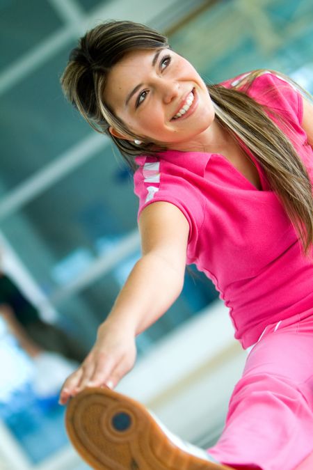 Woman at the gym doing stretching exercises and smiling on the floor