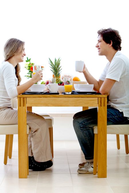 Beautiful couple eating breakfast and smiling indoors
