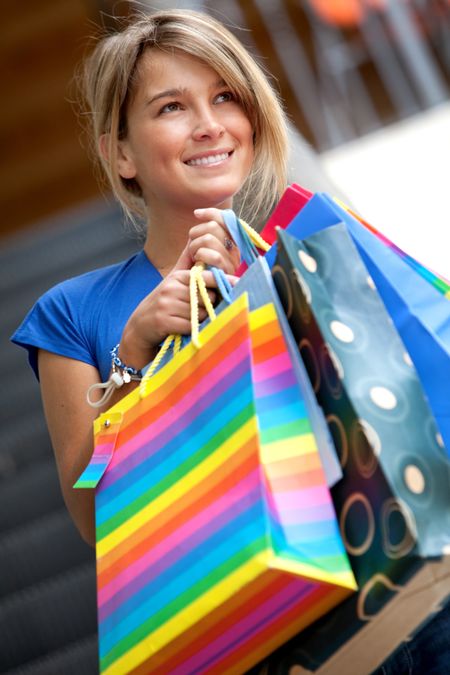 happy woman smiling with shopping bags in a mall