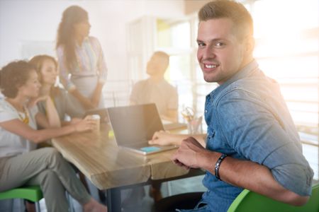 Image of a succesful casual business man using laptop during meeting