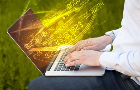 Man typing on modern notebook with future number technology data coming out
